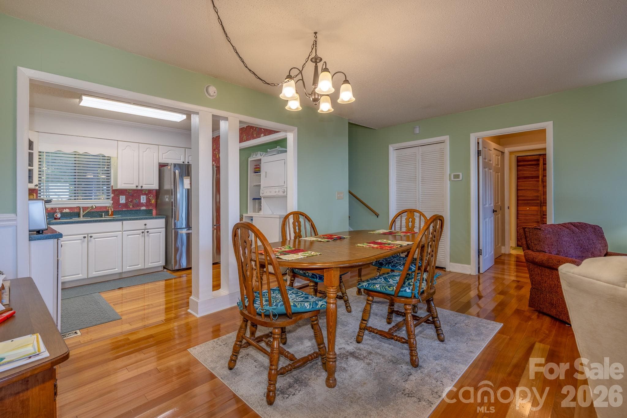 Bright dining area with hardwood floors and an open connection to the kitchen, providing a comfortable space for everyday meals and entertaining. - 524 Three Mile Knob Road, Pisgah Forest