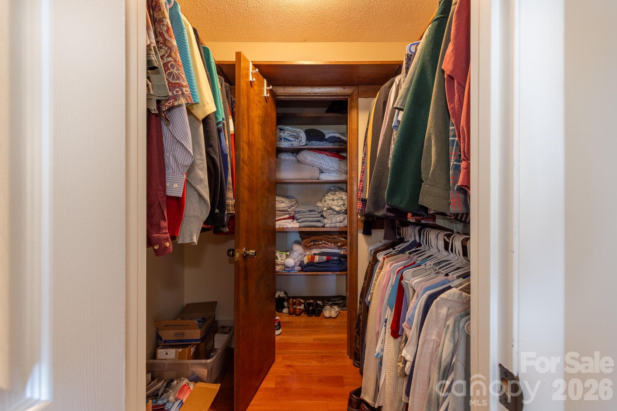 Generous walk-in closet with hanging space on both sides and built-in shelving for additional storage and organization. - 524 Three Mile Knob Road, Pisgah Forest