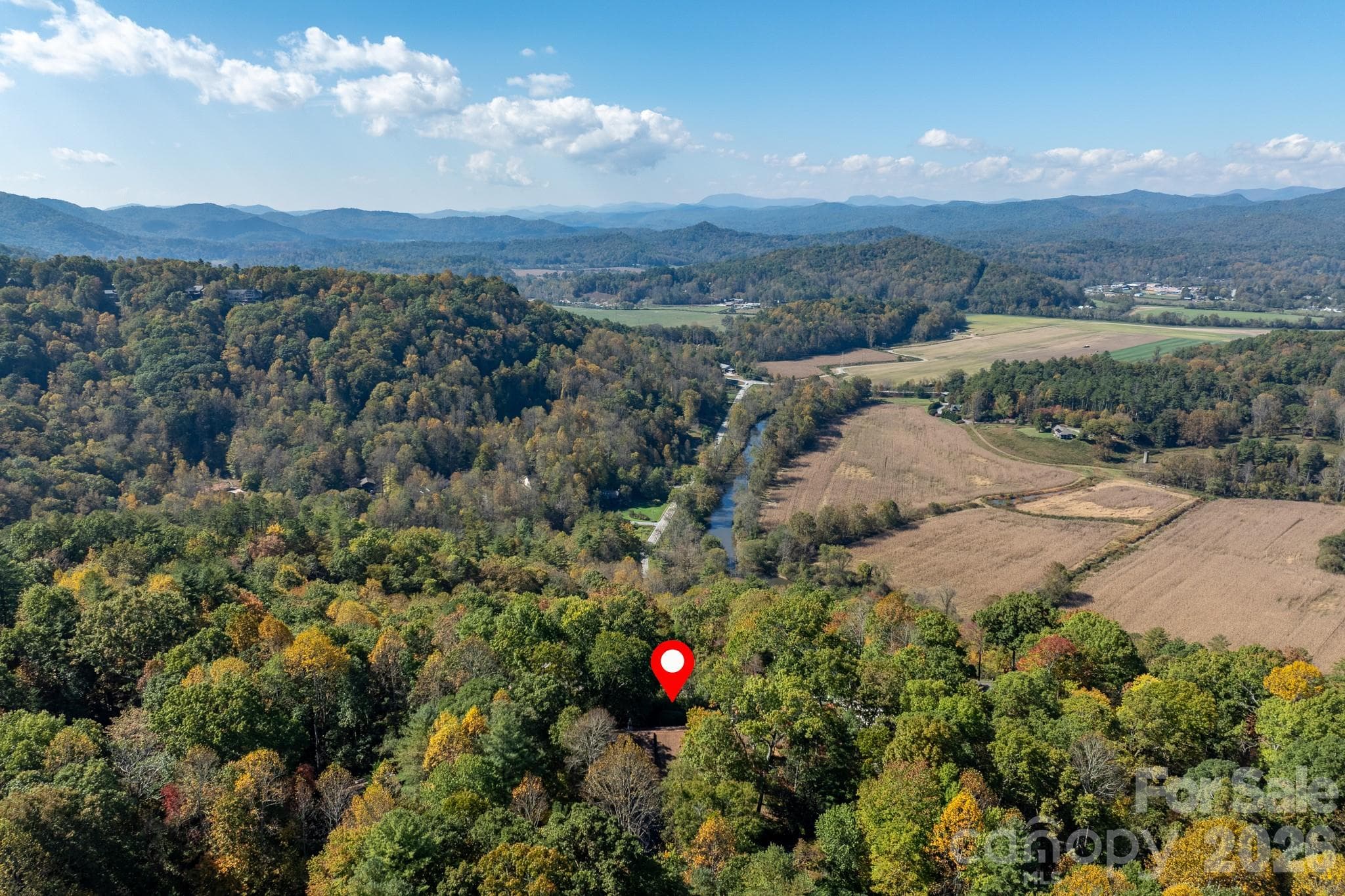 Spectacular aerial view of the valley, winding waterway, and layered Blue Ridge Mountains extending toward the horizon. - 524 Three Mile Knob Road, Pisgah Forest