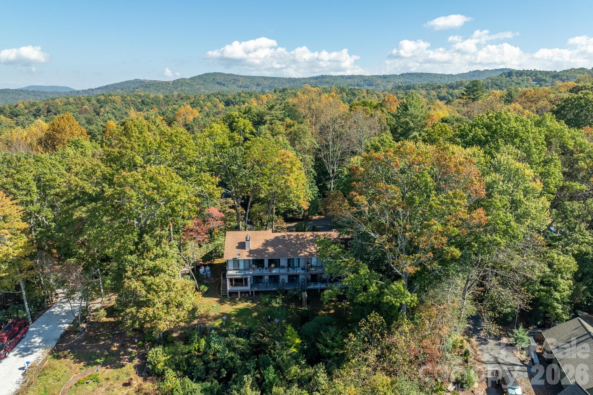 Aerial view of the condominium building nestled among mature trees, with spacious decks overlooking the beautifully wooded surroundings. - 524 Three Mile Knob Road, Pisgah Forest