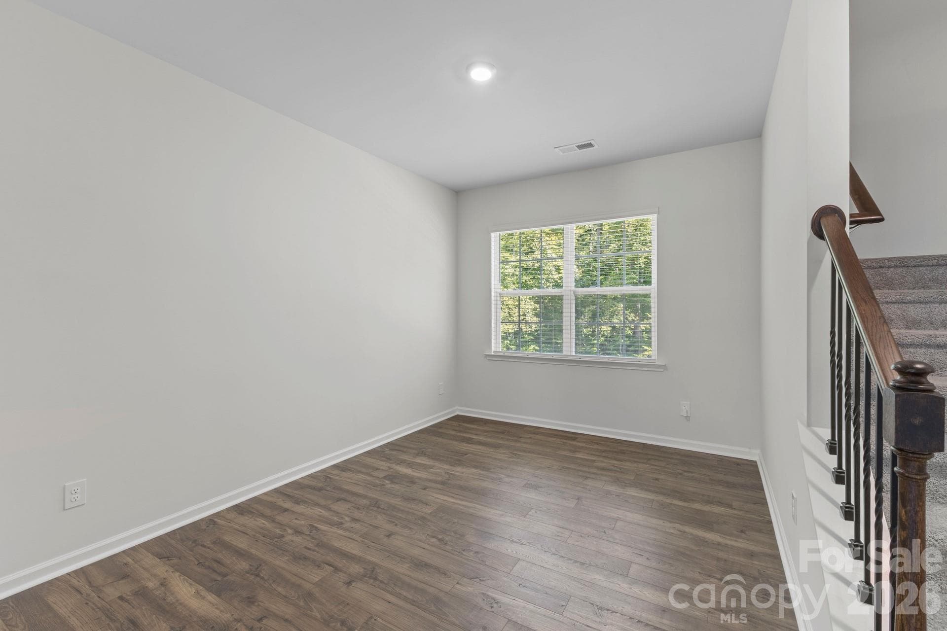The spacious formal dining room features low-maintenance LVP flooring and large double windows that look out over a peaceful, private wooded backyard. - 3741 Stanley Creek Drive, Mount Holly