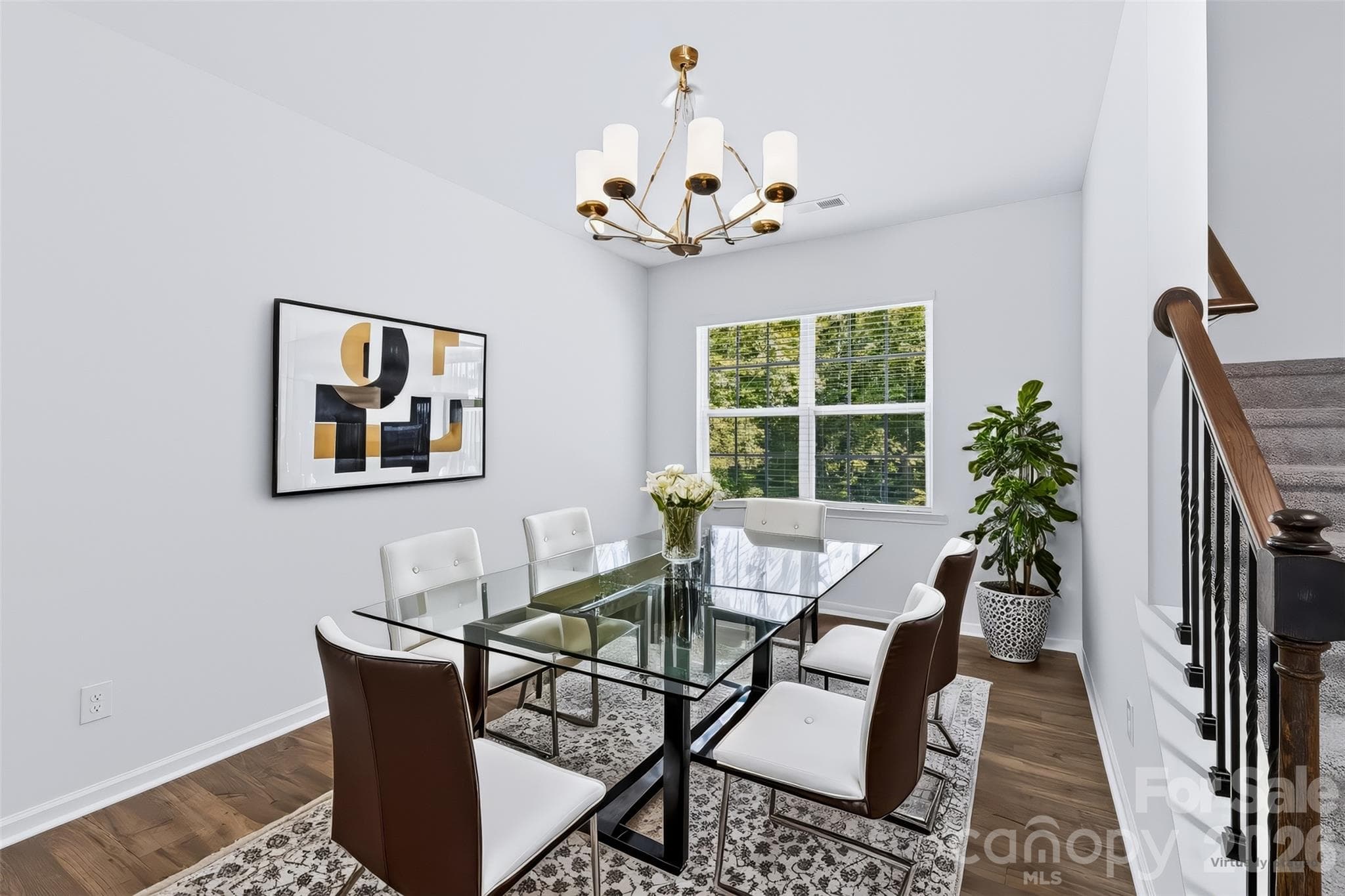 Double windows frame peaceful backyard views in the spacious formal dining room, perfectly accented by an open railing with modern black metal balusters. Complete with durable LVP floors, this flexible room offers an excellent setup for either formal dining or a relaxed, cozy den. - 3741 Stanley Creek Drive, Mount Holly