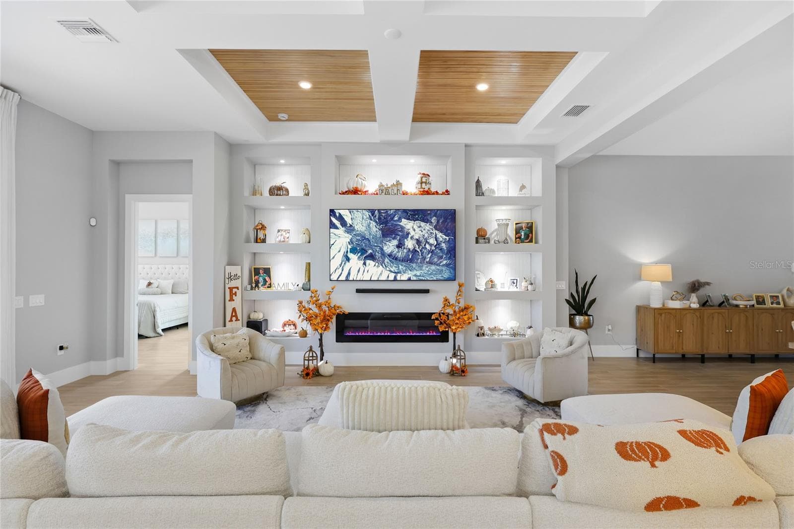Custom built-in cabinetry with elegant display shelving and a striking fireplace creates a sophisticated focal point in the living room, blending timeless design with warmth and style. - 14726 EAGLE BRANCH DR, NOKOMIS