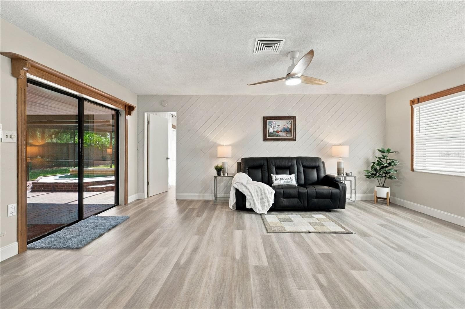 20. Family Room (10.10 x 18.9') Features a Wood Accent Wall.. Great Light, a Part of the Great Room! - 112 PEACOCK CIR, SAFETY HARBOR