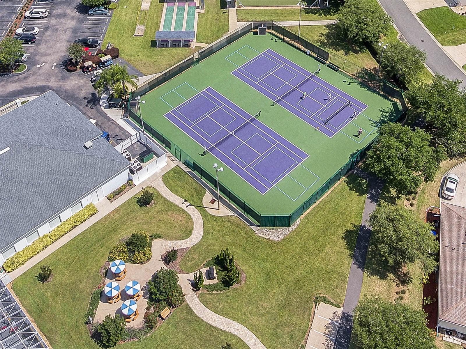 Courts and shaded seating near the clubhouse. - 4900 CANOE CT, TAVARES