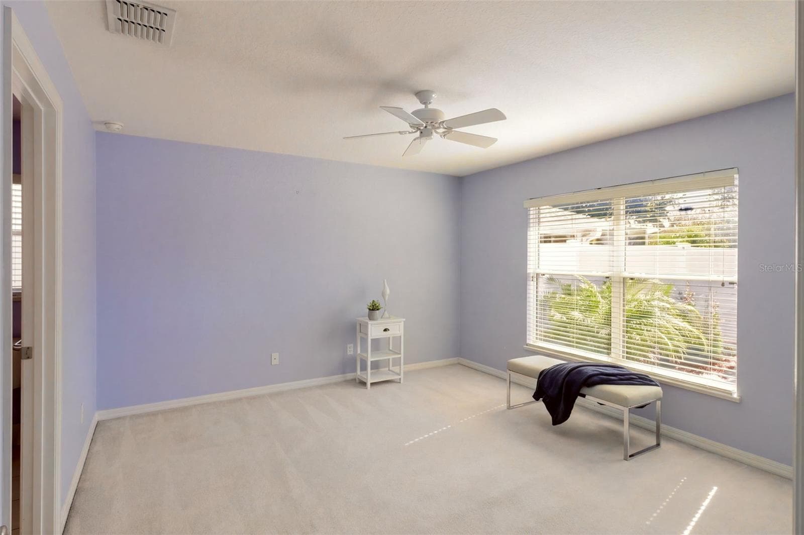 The primary bedroom offers a walk-in closet and ensuite bathroom - 3437 GRENVILLE DR, WINTER HAVEN
