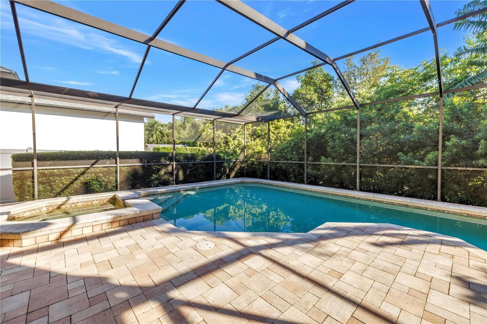 This beautifully designed paver pool deck is engineered to stay cool during the summer and warm in the winter, providing year-round comfort for outdoor relaxation. - 1186 GASPARILLA DR NE, ST PETERSBURG