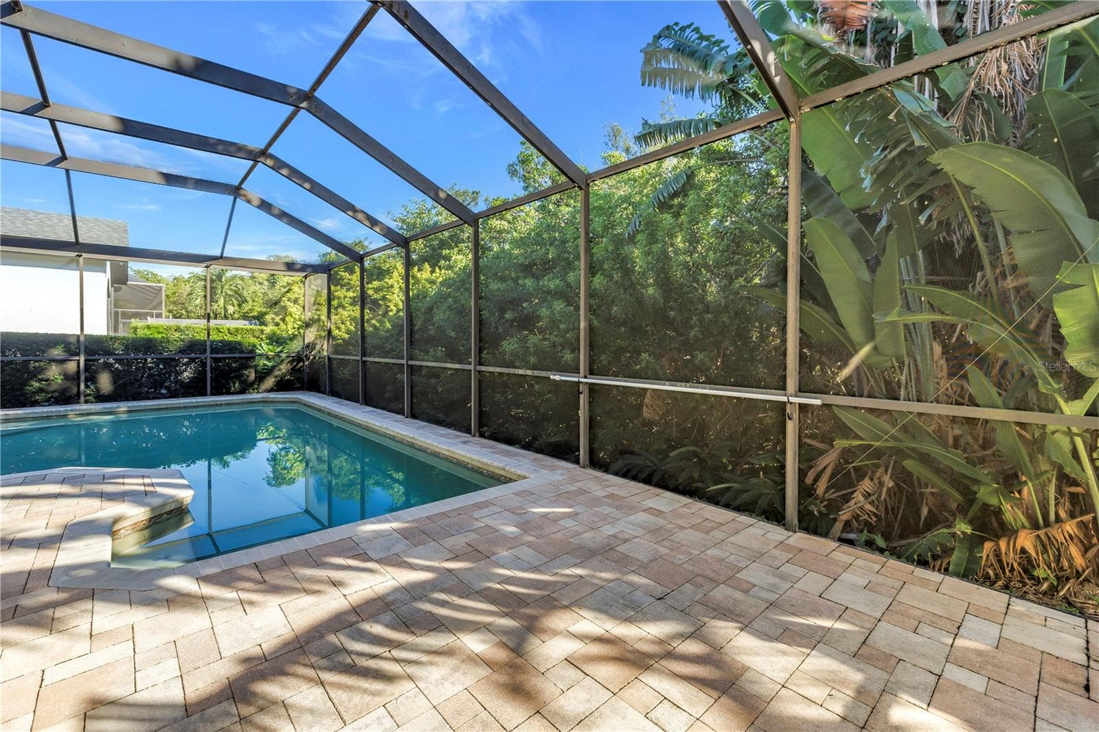 This stunning pool area features multiple access points, including convenient in-pool seating for ultimate relaxation. The surrounding preserve provides a natural, scenic backdrop while offering excellent protection from high winds and storms. - 1186 GASPARILLA DR NE, ST PETERSBURG