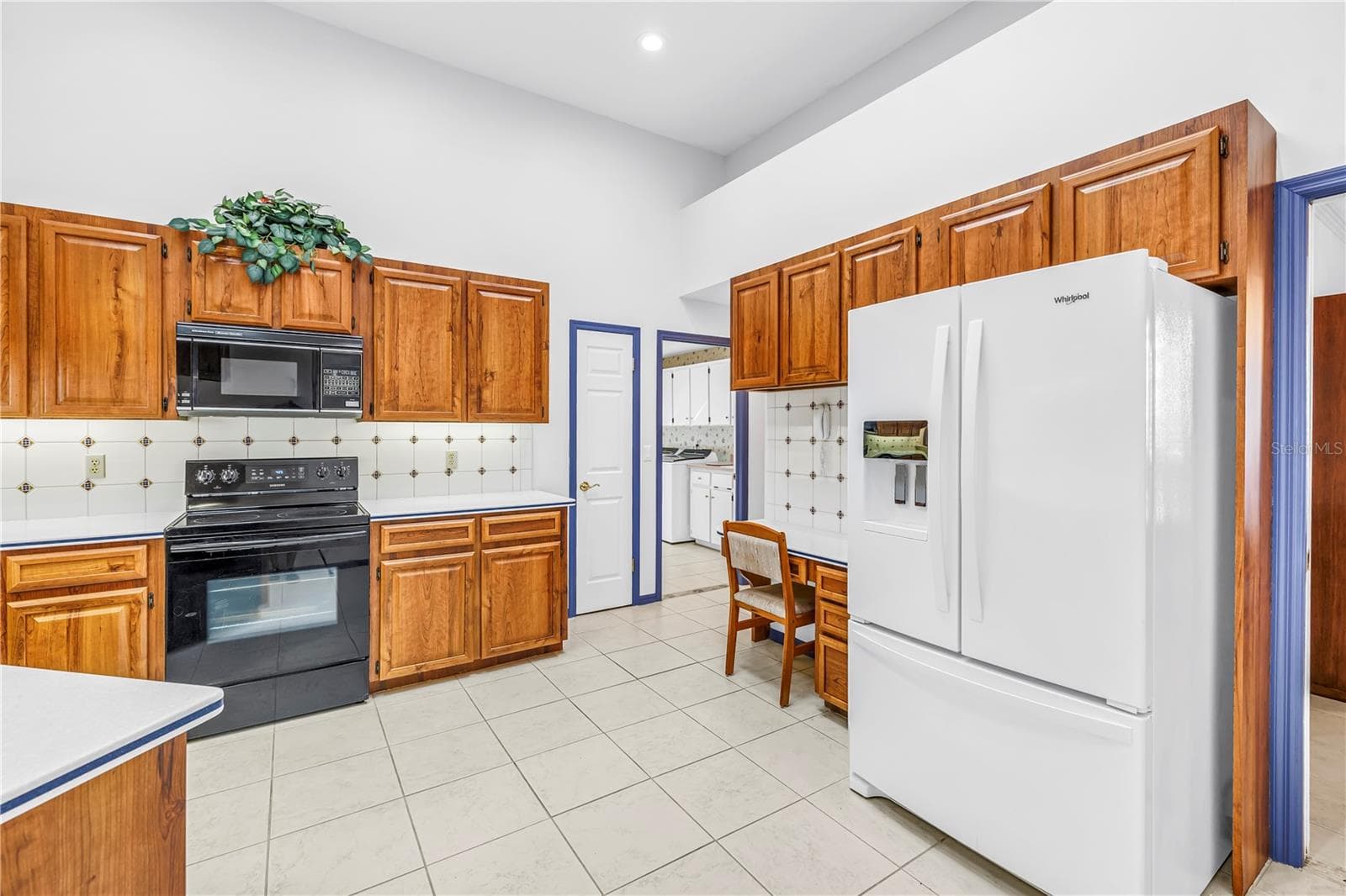 Garage access, large walk-in pantry, laundry room, all on this side of the house. Newer refrigerator. - 1186 GASPARILLA DR NE, ST PETERSBURG