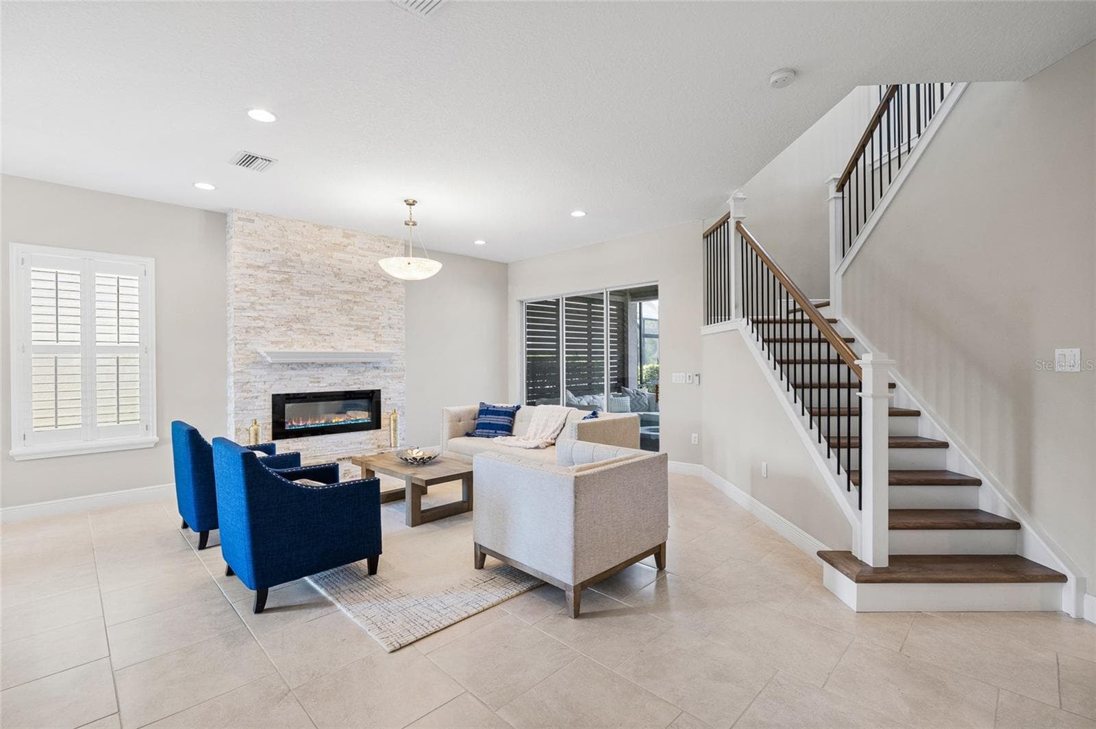 Formal living room with electric fireplace and stone accent wall - 30351 TRISTANIA CT, WESLEY CHAPEL
