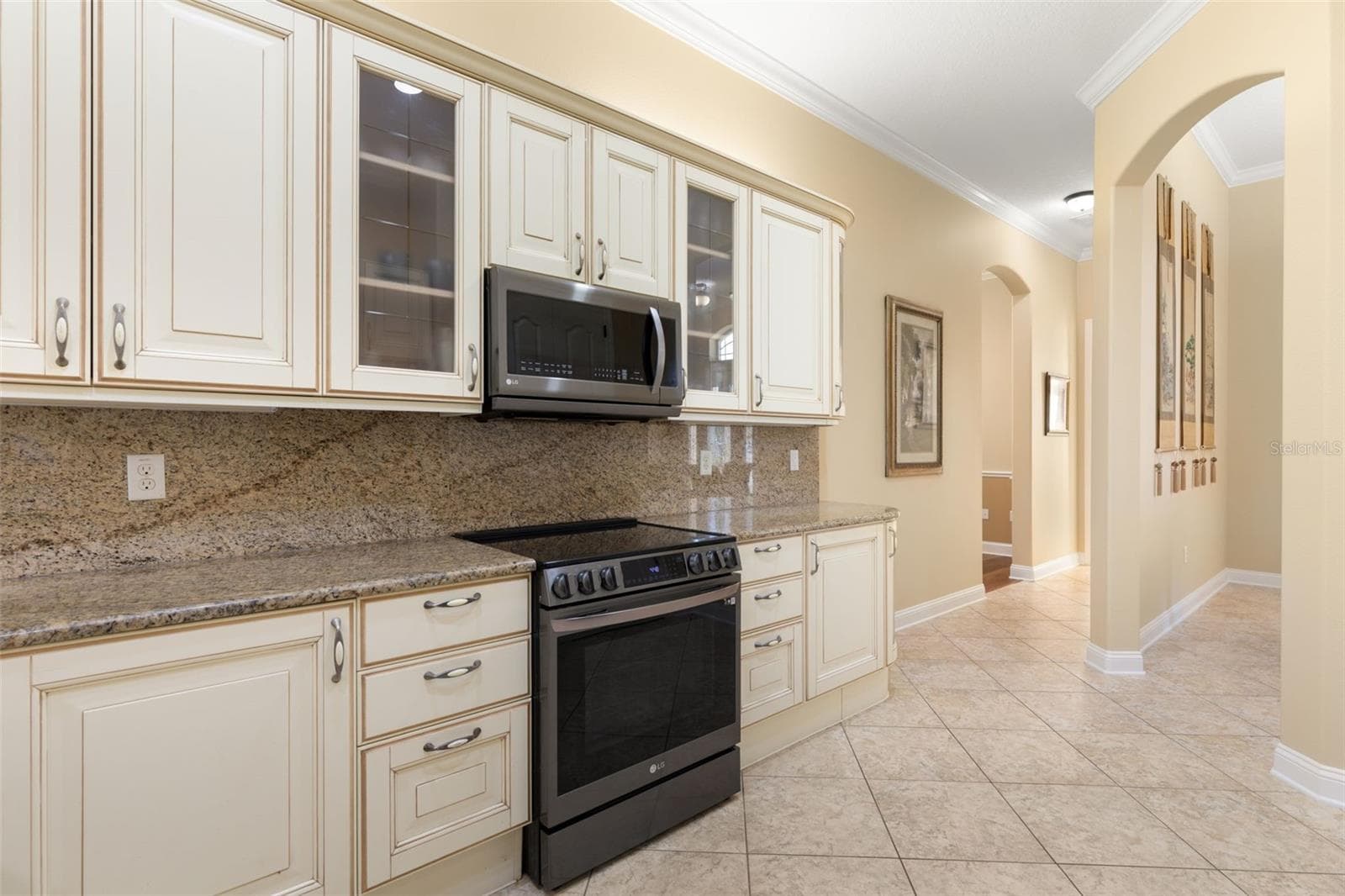 Beautifully detailed cabinetry, glass-front accents and graceful archways add character and architectural charm. - 25 EMERALD LAKE CT, PALM COAST