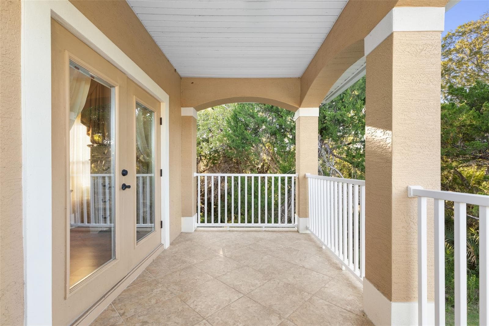 Another perspective of the covered balcony highlights its generous space, tiled flooring and direct access from the upstairs suite. - 25 EMERALD LAKE CT, PALM COAST