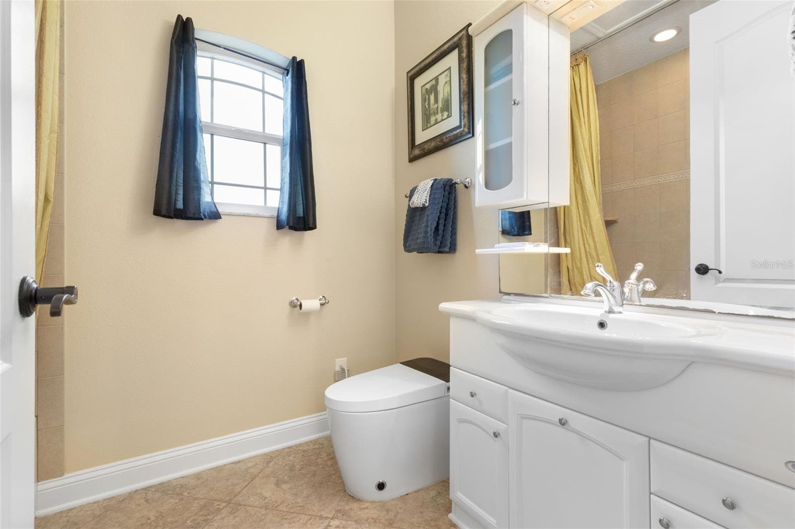 A private full bathroom complements the upstairs suite, featuring a vanity with storage, natural light and a tub/shower combination. - 25 EMERALD LAKE CT, PALM COAST