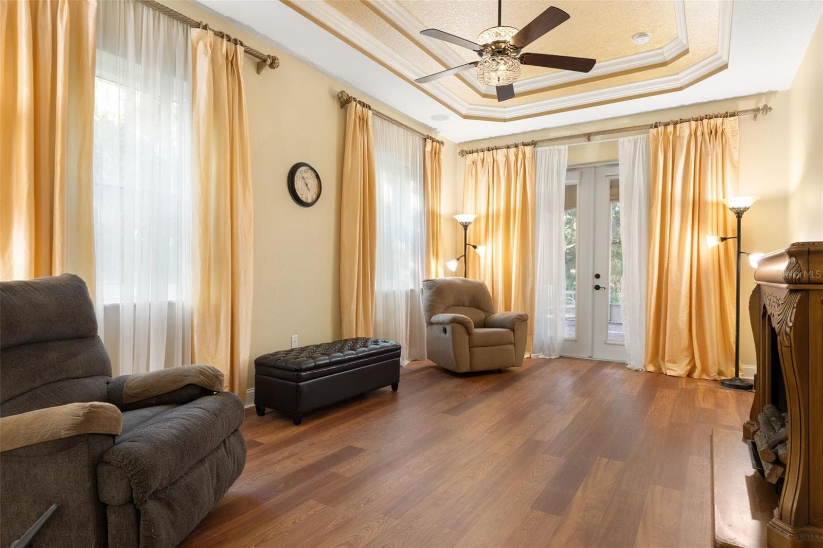 A spacious first-floor primary retreat featuring an elegant tray ceiling, abundant natural light and French doors opening to the screened lanai. - 25 EMERALD LAKE CT, PALM COAST